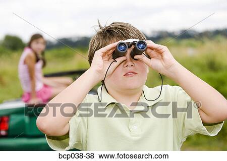 Girl sitting on car as brother uses binoculars View Large Photo Image Stock Photo - Girl sitting on car as brother uses binoculars. Fotosearch