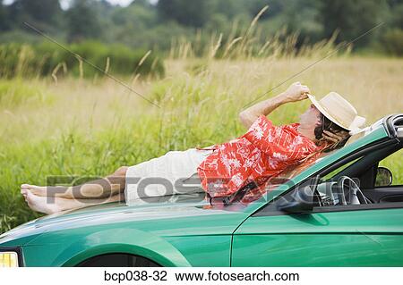 Man resting on a car View Large Photo Image Stock Image - Man resting on a car. Fotosearch
