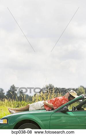 Man resting on car View Large Photo Image Stock Photo - Man resting on car. Fotosearch