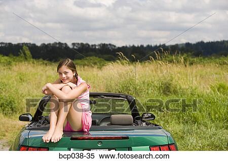 Portrait of girl sitting on car View Large Photo Image Stock Photography - Portrait of girl sitting on car. Fotosearch