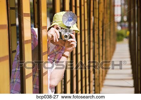 Stock Photo - Tourist taking a photo outdoors. Fotosearch