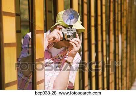 Stock Photo - Tourist taking a photo outdoors. Fotosearch