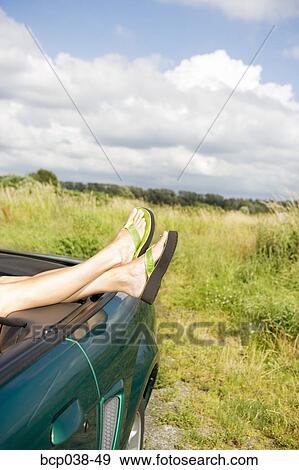 Woman resting feet on car View Large Photo Image Stock Photo - Woman resting feet on car. Fotosearch