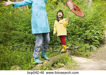 Balancing mom and laughing daughter View Large Photo Image Stock Photograph - Balancing mom and laughing daughter. Fotosearch