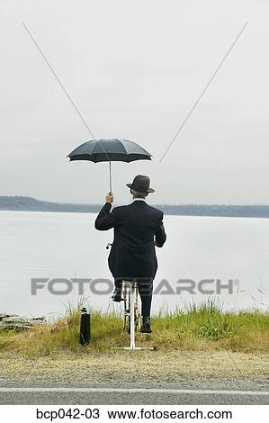 Businessman riding stationary bike by lake View Large Photo Image Stock Image - Businessman riding stationary bike by lake. Fotosearch