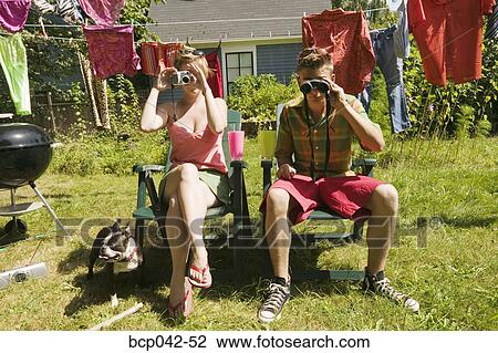 Stock Image - Couple with camera and binoculars. Fotosearch