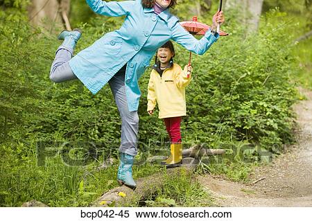 Daughter laughing at mom balancing on log View Large Photo Image Stock Photography - Daughter laughing at mom balancing on log. Fotosearch