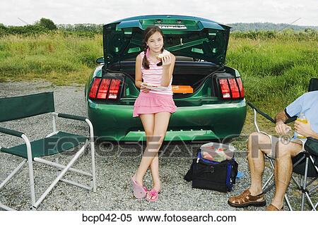 Girl eating picnic lunch outside car View Large Photo Image Stock Photography - Girl eating picnic lunch outside car. Fotosearch