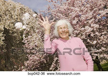 Happy woman throwing flowers View Large Photo Image Stock Photograph - Happy woman throwing flowers. Fotosearch