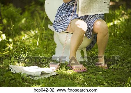 Woman sitting on toilet in grass View Large Photo Image Stock Image - Woman sitting on toilet in grass. Fotosearch