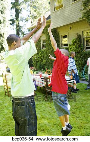 Picture - Boys giving each other a high five. Fotosearch