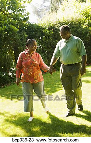 Stock Image - Couple holding hands outdoors. Fotosearch