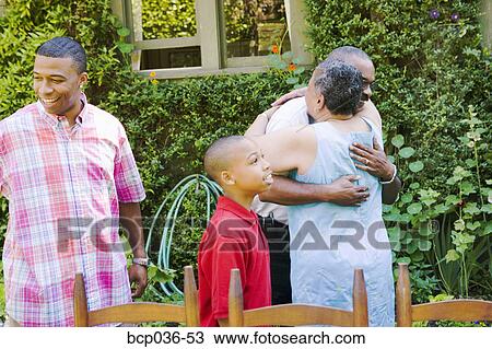 Stock Image - Couple hugging at family picnic. Fotosearch
