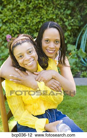 Stock Image - Daughter hugging her mother. Fotosearch