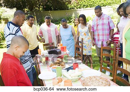 Picture - Family holding hands at picnic. Fotosearch
