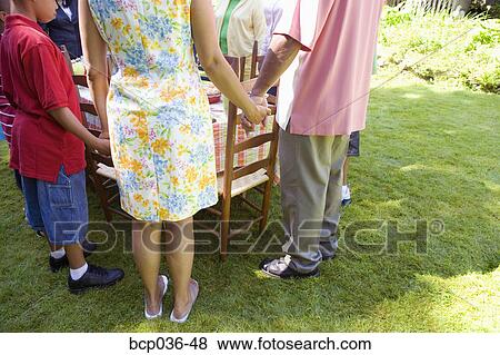 Stock Photo - Family holding hands at picnic. Fotosearch
