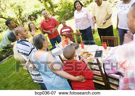 Stock Photo - Family preparing to sit down at picnic. Fotosearch