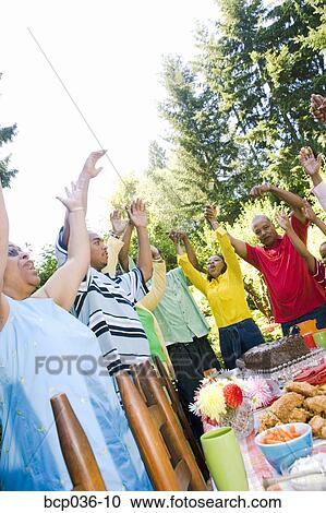 Stock Image - Family singing at summer picnic. Fotosearch