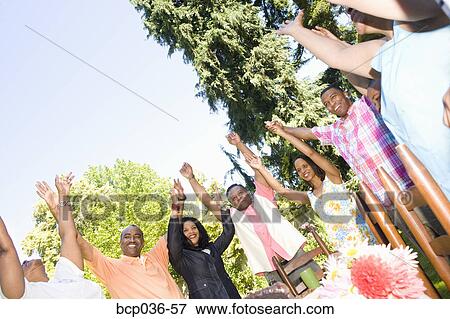 Family with upraised arms at picnic View Large Photo Image Stock Photo - Family with upraised arms at picnic. Fotosearch
