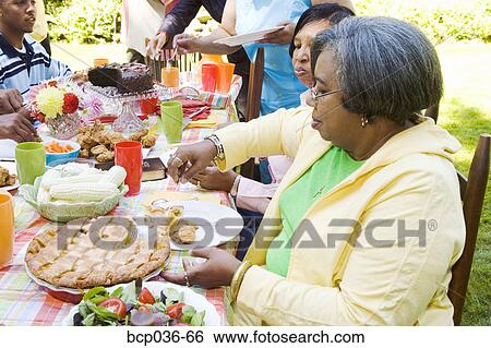 Woman selecting desert at picnic View Large Photo Image Stock Photograph - Woman selecting desert at picnic. Fotosearch