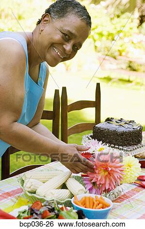 Stock Photograph - Woman setting the table for a picnic. Fotosearch