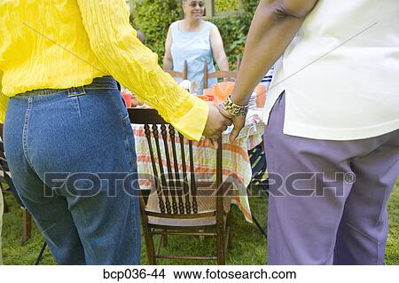 Women holding hands at picnic View Large Photo Image Picture - Women holding hands at picnic. Fotosearch