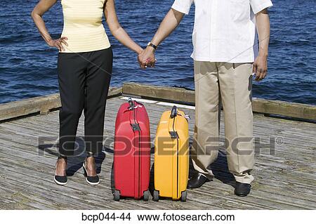 Couple with luggage waiting on pier View Large Photo Image Picture - Couple with luggage waiting on pier. Fotosearch