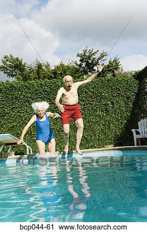 Senior couple jumping into pool View Large Photo Image Stock Image - Senior couple jumping into pool. Fotosearch
