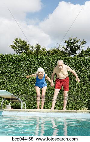 Senior couple preparing to dive into pool View Large Photo Image Stock Photo - Senior couple preparing to dive into pool. Fotosearch