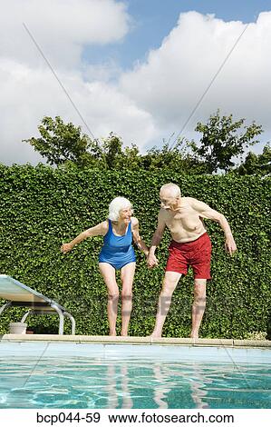 Senior couple preparing to dive into pool View Large Photo Image Stock Photo - Senior couple preparing to dive into pool. Fotosearch