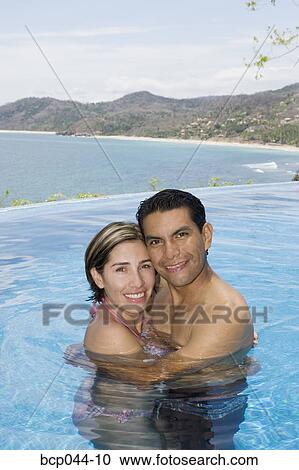 Vacationing couple in swimming pool View Large Photo Image Stock Image - Vacationing couple in swimming pool. Fotosearch