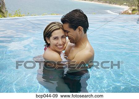 Stock Photo - Vacationing couple in swimming pool. Fotosearch