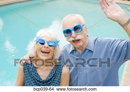 Picture - Senior couple in wacky sunglasses. Fotosearch