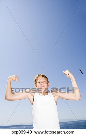 Young boy flexing his muscles View Large Photo Image Stock Image - Young boy flexing his muscles. Fotosearch