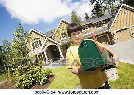 Boy holding new mailbox outside house View Large Photo Image Picture - Boy holding new mailbox outside house. Fotosearch