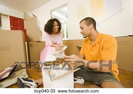 Couple unpacking boxes in new home View Large Photo Image Stock Image - Couple unpacking boxes in new home. Fotosearch