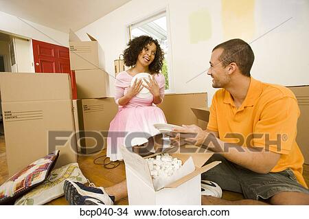 Couple unpacking dishes in new home View Large Photo Image Picture - Couple unpacking dishes in new home. Fotosearch
