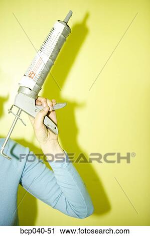 Female hand holding caulk gun View Large Photo Image Stock Image - Female hand holding caulk gun. Fotosearch