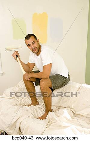 Man with paint roller on couch View Large Photo Image Stock Image - Man with paint roller on couch. Fotosearch