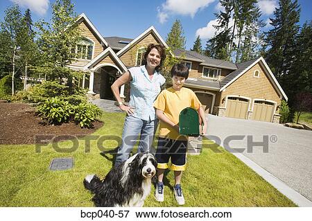 Stock Photo - Mom with son and dog outside house. Fotosearch