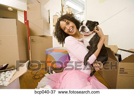 Woman holding dog in new home View Large Photo Image Stock Photo - Woman holding dog in new home. Fotosearch