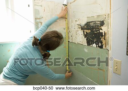 Woman measuring damaged shower wall View Large Photo Image Stock Image - Woman measuring damaged shower wall. Fotosearch