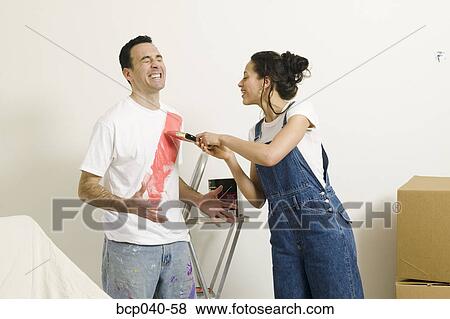 Woman painting on man's shirt View Large Photo Image Stock Photo - Woman painting on man's shirt. Fotosearch