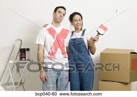 Stock Image - Woman showing off paint on man's shirt. Fotosearch