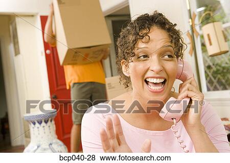 Woman talking on phone while moving View Large Photo Image Stock Photo - Woman talking on phone while moving. Fotosearch