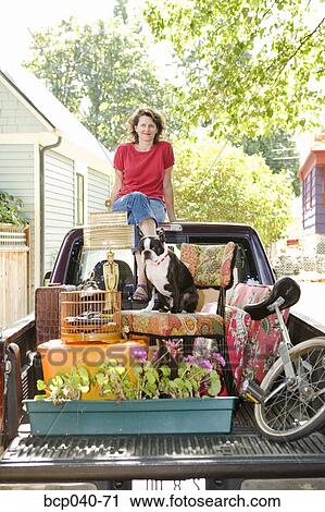 Stock Image - Woman with loaded pickup and dog. Fotosearch