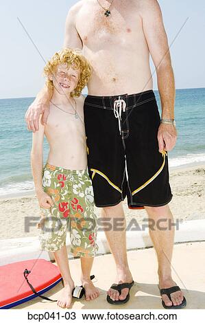 Boy posing with dad on beach View Large Photo Image Stock Image - Boy posing with dad on beach. Fotosearch