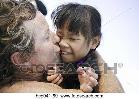 Closeup of father kissing daughter View Large Photo Image Stock Photo - Closeup of father kissing daughter. Fotosearch
