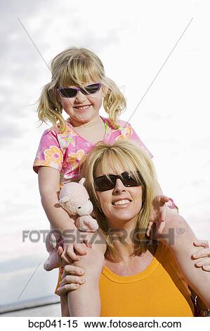Stock Photography - Daughter on mom's shoulders. Fotosearch