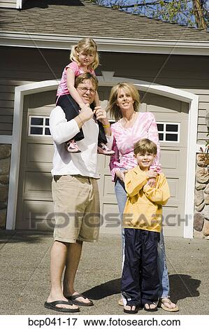 Stock Photo - Family portrait outside house. Fotosearch